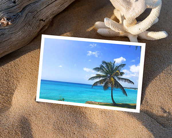 Postcards lying on sandy beach, capturing a relaxed coastal vibe, perfect for travel memories or vacation greetings.