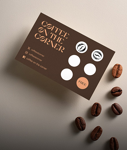 A coffee company loyalty card displayed alongside a handful of coffee beans.